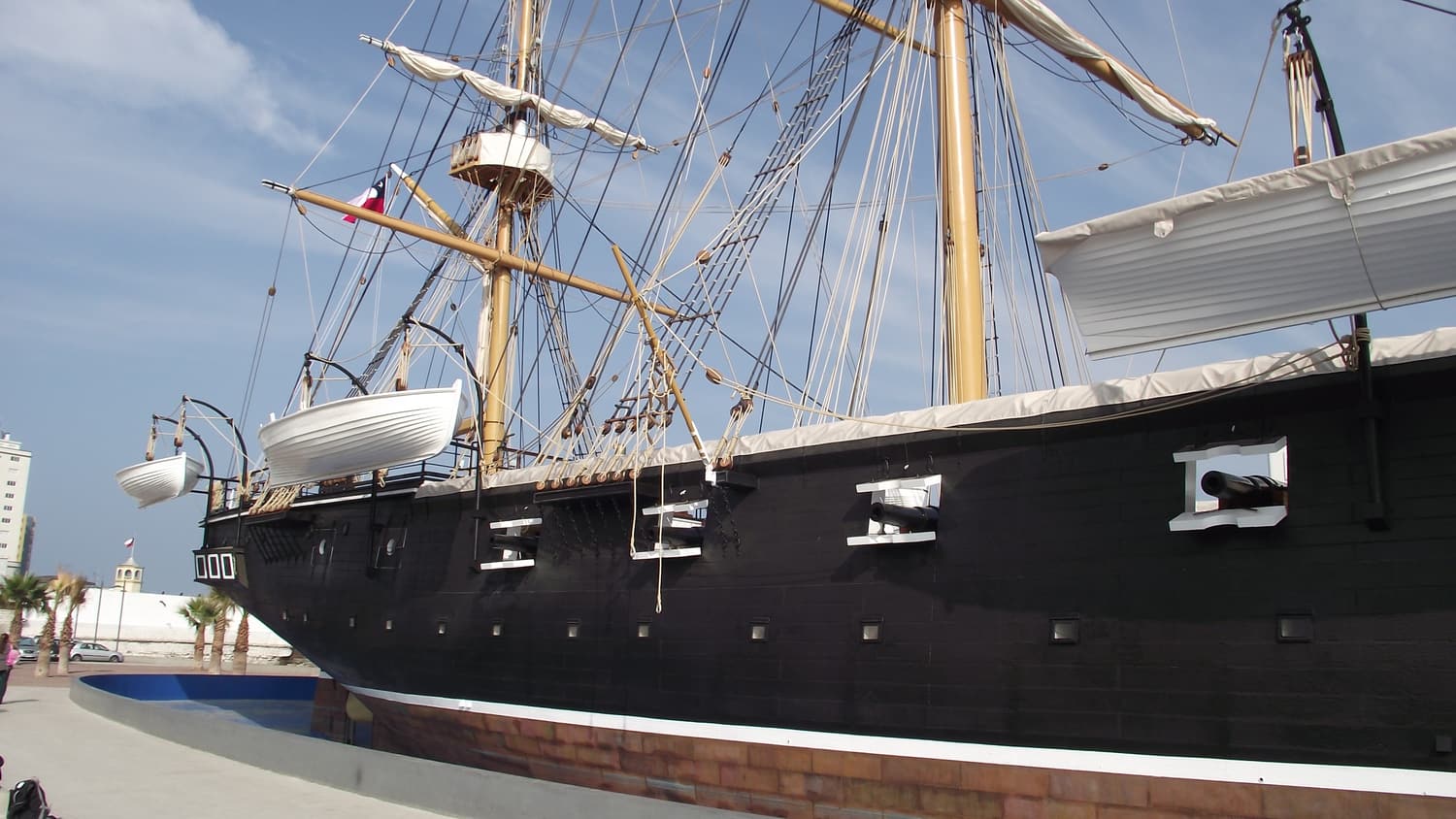 The black hull and masts of the full-scale replica corvette Esmeralda at the museum in Iquique