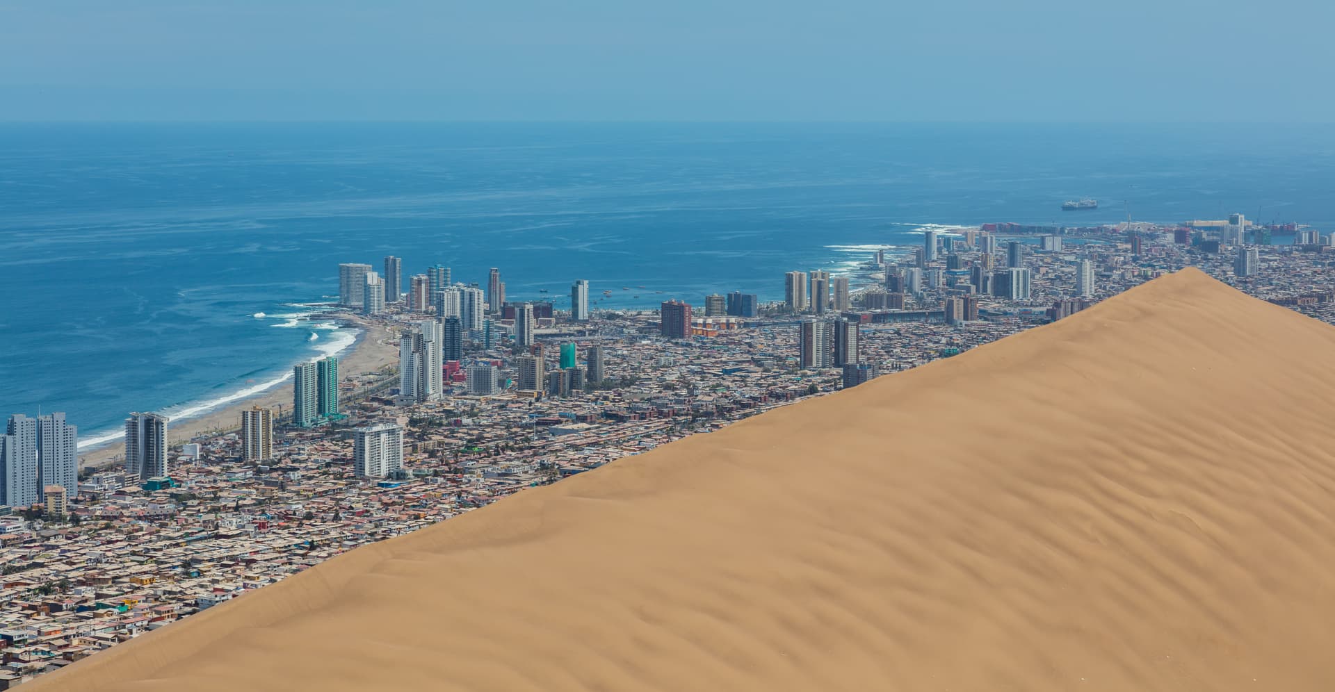 The towers of Iquique and the Pacific coast seen from the crest of the Cerro Dragón dune