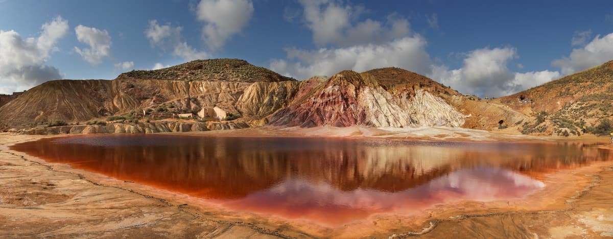 The red water of the Laguna Roja beneath mineral-coloured hills