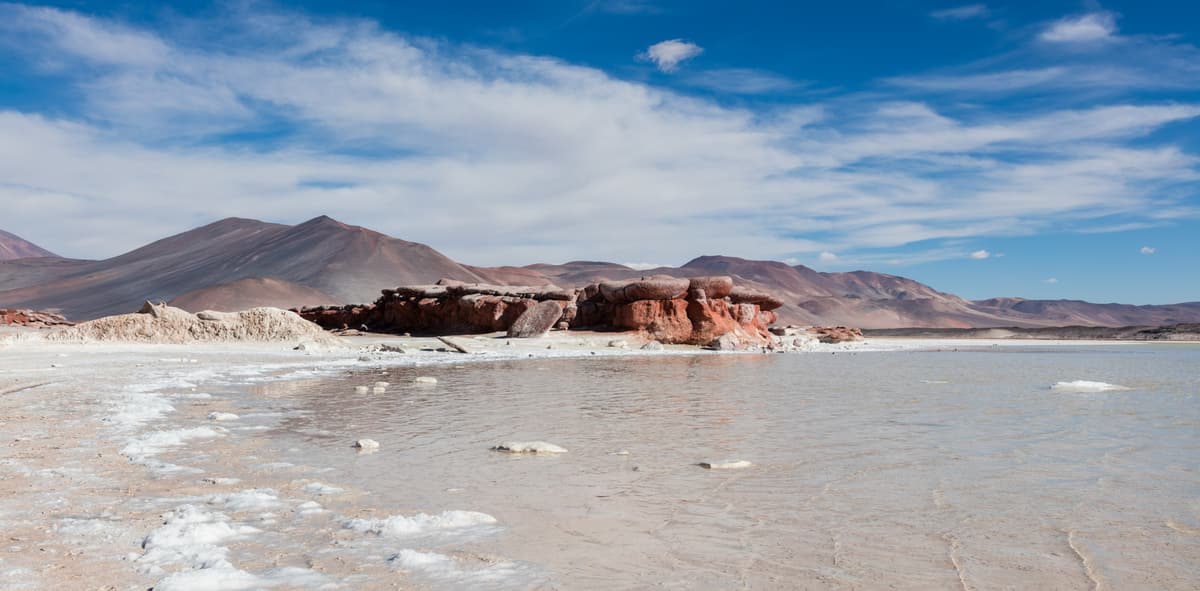 Red rocks and pale blue water at Piedras Rojas in the Atacama highlands